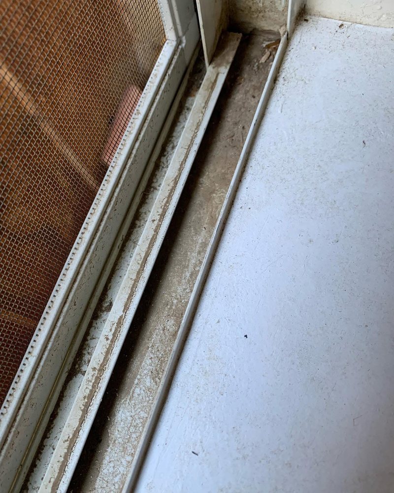 Sliding door track filled with dirt before cleaning